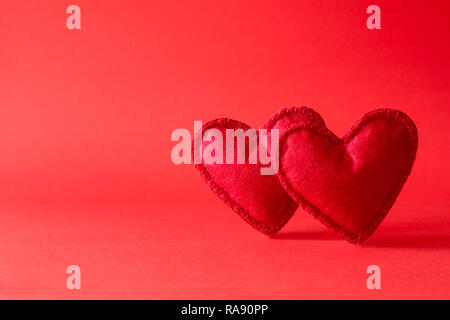 Filz Herzen auf rotem Hintergrund mit Bokeh. Valentine's Day Feier oder Liebe Konzept. Platz kopieren Stockfoto