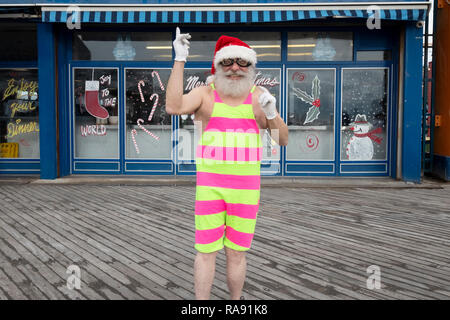 Stellen Portrait eines älteren Mannes in einer Santa Hut & Weihnachten Body am Tag der jährlichen Polar Bear Club in Coney Island, Brooklyn, NYC schwimmen. Stockfoto