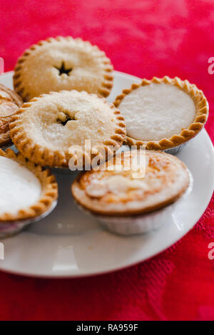 Mince Pies auf Weihnachten Tischdekoration mit mit rotem Tuch geschossen auf flache Tiefenschärfe Stockfoto