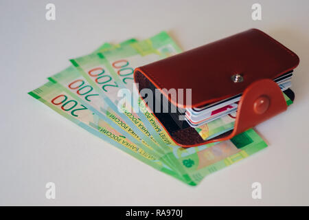 Braunes Leder-Etui mit Plastikkarten und der Russischen Zentralbank Banknoten. Russische Geld für 200 Rubel. Stockfoto