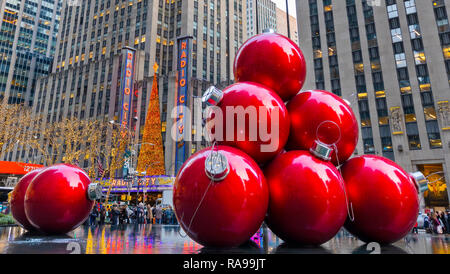 Riesige rote Weihnachtsverzierungen in der Nähe der Radio City Music Hall an der 6th Avenue in New York City. Stockfoto