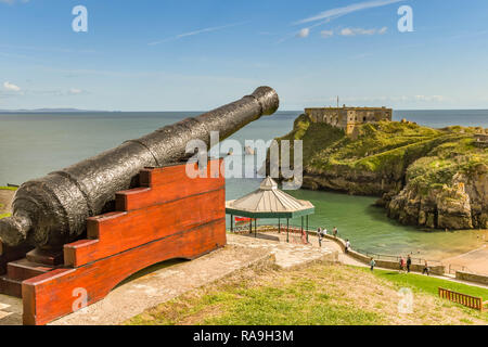 TENBY, Pembrokeshire, Wales - AUGUST 2018: alte Kanone mit Blick auf das Schloss und Strand St Catherine's Insel in Tenby, West Wales. Stockfoto