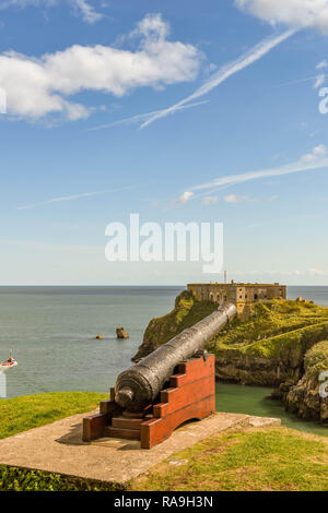 TENBY, Pembrokeshire, Wales - AUGUST 2018: Weitwinkelaufnahme eines antiken Kanone mit Blick auf das Schloss und Strand St Catherine's Insel in Tenby, West Stockfoto