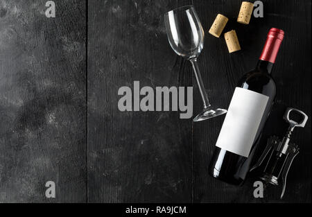 Rotwein Flasche mit Korkenzieher, Korken und Wein Glas auf dunklen Holztisch flach von oben mit Kopie Raum Stockfoto