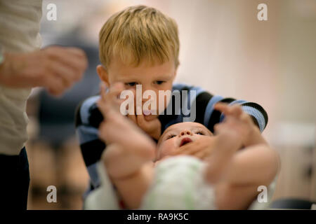 Kleinen Jungen neugierig an seinen Bruder lag auf seinem Rücken. Stockfoto