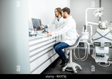 Zahnarzt mit junge Frau Assistant arbeiten mit Computer in der Zahnarztpraxis Stockfoto