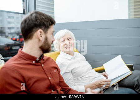 Mann mit dem Lächeln ältere Frau warten auf den Arzt im Krankenhaus Empfang Stockfoto