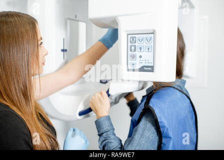 Medical Assistant Einrichten x-ray Maschine für die Panorama-aufnahme des Kiefers Stockfoto