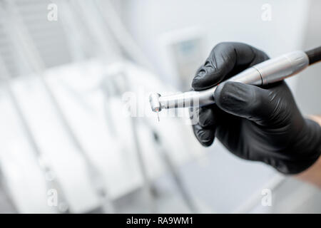 Nahaufnahme einer zahnmedizinischen Bohrer mit Düse in die Hände in Schwarz medizinische Handschuhe Stockfoto