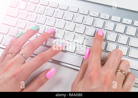 Detailansicht eines Business frau Hände schreiben auf drahtlose Computer Tastatur auf Office Tabelle. Weiches Blitz Stockfoto
