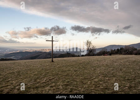 Spätherbst Tag auf Loucka Hügel in Slezske Beskiden mit Holzkreuz, Wiese, Berge, auf den Hintergrund und den blauen Himmel mit Wolken Stockfoto