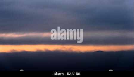 Das Schloss durch den Nebel in orangefarbenes Licht am Morgen eingehüllt Stockfoto