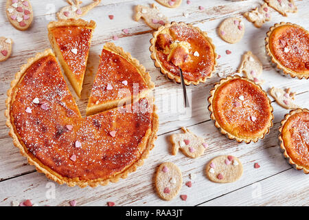 Köstliche Schweizer Ostern Grieß Torten bestreut mit Puderzucker, Torte de Paques, Osterchuechli in tart Muscheln, auf einem Holztisch mit eingerichtet Stockfoto