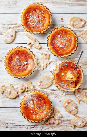 Köstliche Schweizer Ostern Grieß Torten bestreut mit Puderzucker, Torte de Paques, Osterchuechli in tart Muscheln, auf einem Holztisch mit eingerichtet Stockfoto