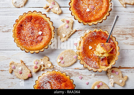 Schweizer Ostern Torten bestreut mit Puderzucker, Torte de Paques, Osterchuechli in tart Muscheln, auf einem Holztisch mit Ostern cookies eingerichtet, hor Stockfoto