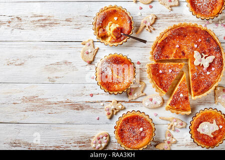 Klassische Schweizer Ostern Reis Torten bestreut mit Puderzucker, Torte de Paques, Osterchuechli in tart Muscheln, auf hölzernen Tisch dekoriert mit Ostern Stockfoto