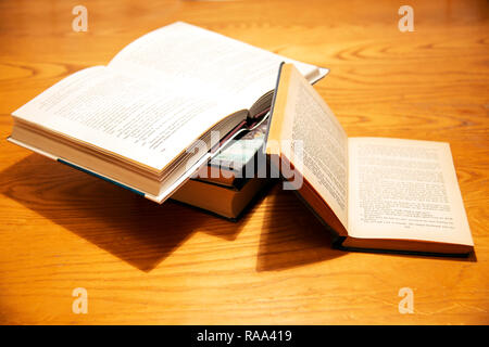 Eine offene Stapel Bücher auf einem Tisch gestapelt Stockfoto