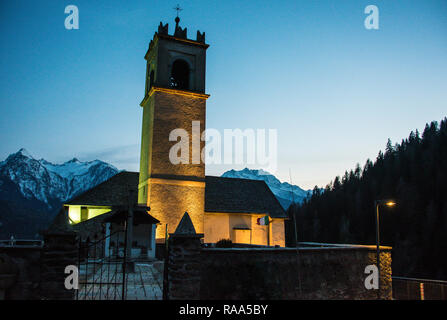 Nacht Foto von Berg Kirche mit Glockenturm und Kreuz. Italienische Alpen im Hintergrund. Castello, eine kleine Stadt in Trient, Trentino, Italien. Stockfoto