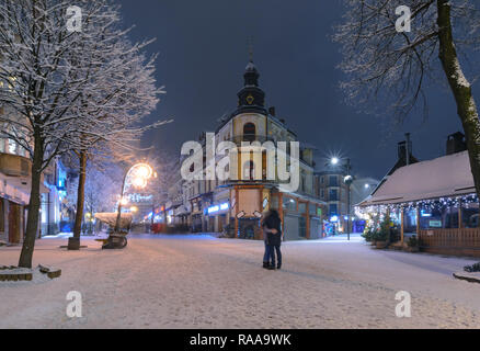 Küssen Paar in der Main Street in Zakopane im schnee abend, Polen. Europa. Stockfoto