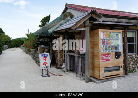 Shop mit getränkeautomat auf der Straße mit traditionellen Steinmauern an der tropischen Insel Taktomi in Japan Stockfoto