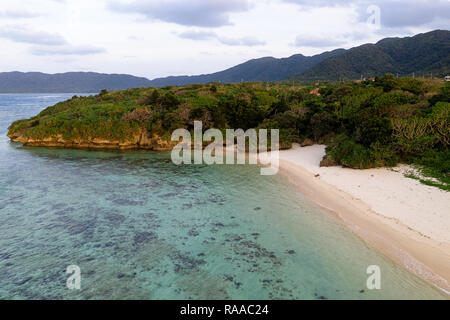 Luftaufnahme über einzigartige tropische Insel mit Berge, einsame weisse Sandstrände und Coral Reef, bei Sonnenuntergang, von Drohne, Ishigaki, Japan Stockfoto