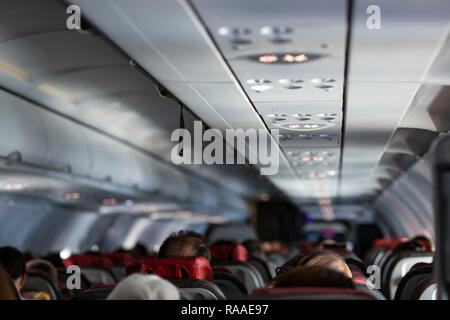 Beifahrersitz, Interieur des Flugzeuges mit der Passagiere auf den Sitzen. Travel Concept, vintage Farbe, selektiven Fokus. Stockfoto