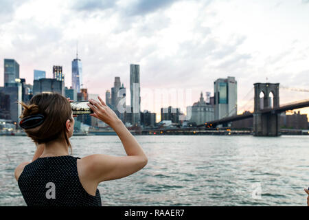 Ein tourist Fotos New York Skyline aus Brooklyn Bridge Park in New York City, USA. Stockfoto