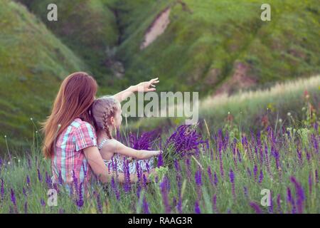 Glückliche Familie - Mutter Tochter schaut in die Ferne im Freien Stockfoto