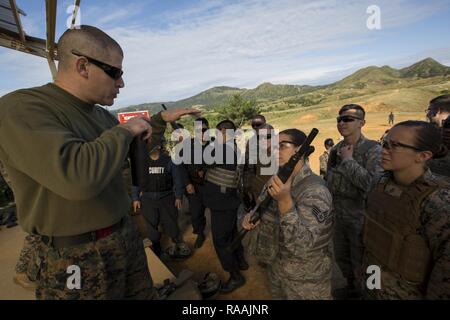 Us Marine Gunnery Sgt. William Radebaugh, nicht-tödliche Waffen Instructor, lehrt US-Marines, Matrosen, Soldaten, Flieger, und Japanische Sicherheitsbeamte, wie die mossberg 12 Gage Schrotflinte während einer Non-Lethal Waffen Instructor Kurs an Bord Camp Hansen, Okinawa, Japan, Jan. 17, 2017 zu verwenden. Der Kurs vermittelt Personal die korrekten Techniken bei der Durchführung von Taser Ausbildung, oleoresin Capsaicin Exposition und riot control Team Taktik. Stockfoto