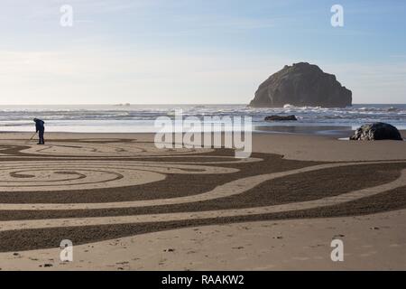 Ein freiwilliger auf einem sand Labyrinth von der Gruppe 'Kreise im Sand" auf Face Rock Beach in Bandon, Oregon, USA erstellt. Stockfoto