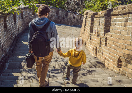 Gerne heiter fröhlichen Touristen Vater und Sohn an der Chinesischen Mauer, das Spaß am Reisen, lächeln, lachen und tanzen in den Ferien Reise in Asien. Chinesische Ziel. Reisen Sie mit Kindern in China Konzept Stockfoto