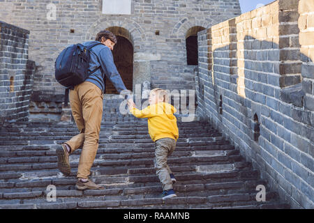 Gerne heiter fröhlichen Touristen Vater und Sohn an der Chinesischen Mauer, das Spaß am Reisen, lächeln, lachen und tanzen in den Ferien Reise in Asien. Chinesische Ziel. Reisen Sie mit Kindern in China Konzept Stockfoto