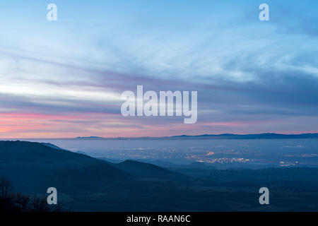 Nebel über der Stadt Madrid und Alcala de Henares bei Sonnenuntergang, bewölkter Himmel, beleuchtet, Nächte, Lichter, Wolkenkratzer. Madrid, Spanien. Stockfoto