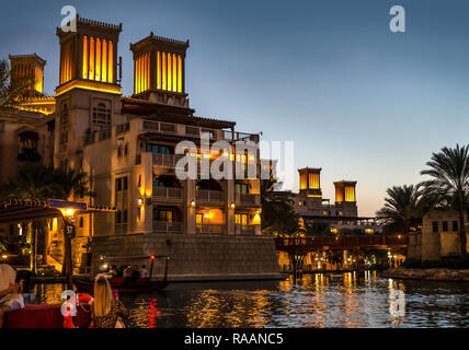 Arabische Architektur in Dubai Souk Madinat Jumeirah bei Nacht mit Licht und Reflexionen. Stockfoto