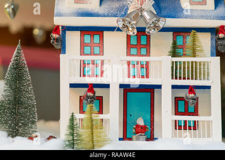 Kleine Süße Weihnachten Haus mit Elfen, Santa Claus und silbernen Glocken hängen von einem Band Stockfoto