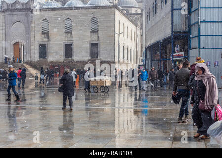 Istanbul, Türkei, 17. Februar 2015: Die Menschen wandern im Schnee in Eminonu, außerhalb der Neuen Moschee (Yeni Camii). Stockfoto