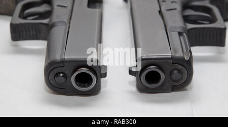 Zwei schwarze halbautomatische Pistolen, ein 9 mm und einen 40-Kaliber auf einem weißen Hintergrund, in der die verschiedenen Größen von Ihnen Stockfoto
