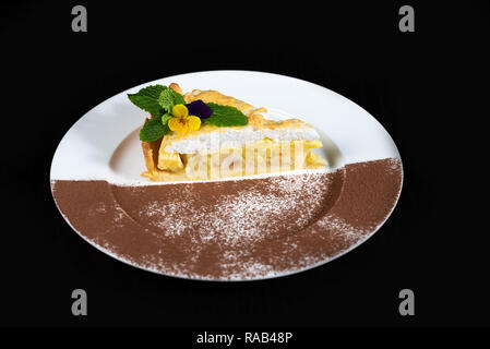 Ein Stück Kuchen mit Äpfeln, hausgemacht auf einem weißen Teller zubereitet. Stockfoto