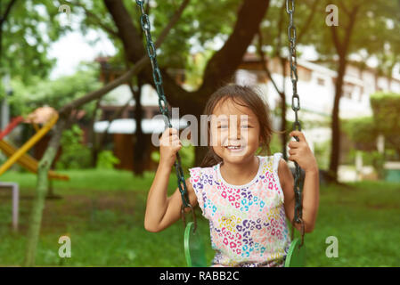 Lifestyle Portrait von asiatischen Mädchen sitzen auf Schaukeln Stockfoto