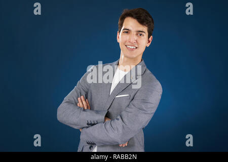 Junger Mann mit verschränkten Armen auf Blau studio Hintergrund isoliert Stockfoto