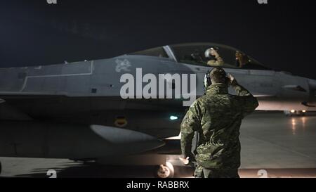 Kapitän David, 79th Expeditionary Jagdgeschwader Piloten, und Staff Sgt. Daniel Lasal, 455Th Expeditionary Aircraft Maintenance Squadron engagierte Crew Chief, einander grüßen, bevor eine Nacht mission Jan. 13, 2017 am Flughafen Bagram, Afghanistan. David trug in der Air Force im Jahr 2004 als F-16 Fighting Falcon Spezialist Avionik und jetzt fliegt der gleichen Zelle verwendete er ein Betreuer für zu sein. Stockfoto