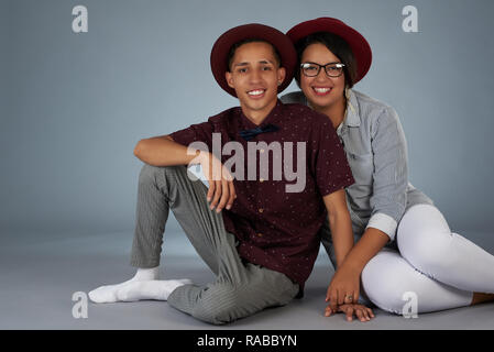Nette junge Hispanic Paar sitzt auf Grau studio Hintergrund Stockfoto