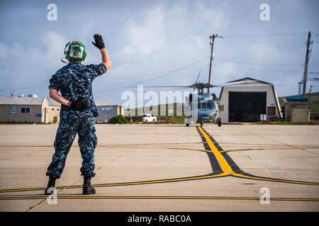 Techniker 2. Klasse Travis Murphy, zugeordnet zu den Hubschrauber Meer Combat Squadron (HSC) 3, Southern California Offshore Bereich (Score) Distanz, leitet eine MH-60S Sea Hawk Hubschrauber die flightline nach Abschluss der Flugbetrieb auf der Insel San Clemente, Calif., Jan. 10, 2016. HSC-3 Partitur Loslösung bietet wichtige Unterstützung für den taktischen Bereich Ausbildung und Prüfung Operationen der US-Marine im pazifischen Flotte Vermögenswerte. Stockfoto