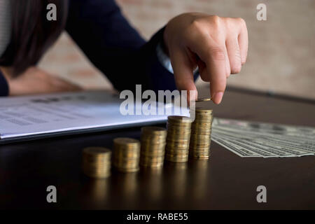 Geschäftsfrau picks Münzen auf den Tisch und zählt Geld. Geschäftskonzept. Stockfoto