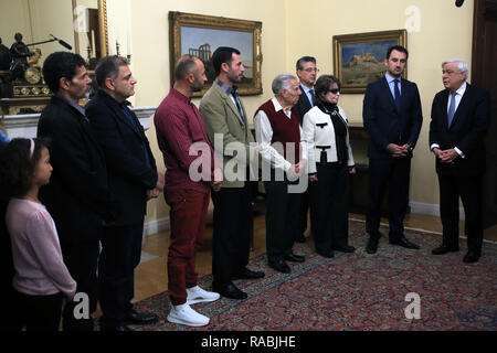 (190103) - Athen, Januar 3, 2019 (Xinhua) - griechische Präsident Prokopis Pavlopoulos (1. R) spricht bei einem Treffen mit den drei Fischer und ihre Familien in die Presidential Villa in Athen, Griechenland, Jan. 2, 2019. Ägypter Nachfrageseite El Khamisi, 50, Mahmoud Moussa, 46, und albanischen Jeka Gani, 35, ihr Leben riskiert, neben vielen anderen einheimischen Fischern am Juli 23, 2018 Rettung Dutzende von Menschen auf der Flucht vor den Flammen, die durch den Küstenort Mati, rund 30 Kilometer nordöstlich von Athen gefegt. Hundert Menschen in den Flammen starben oder das Meer, der Abend. Griechische Präsident Prokopis Pavlo Stockfoto