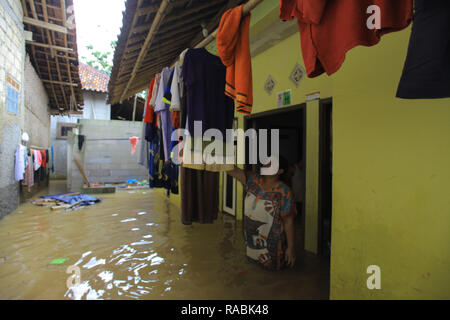 Bogor, West Java, Indonesien. 2 Jan, 2019. Bewohner gesehen Ihr Haus Reinigung während eines Hochwassers. Dutzende Bewohner waren aufgrund der Flutkatastrophe in hitdorf Rancamaya Cikobak RT 03/04, Rancamaya, Bogor Stadt evakuiert. Diese Flut begannen dutzende Häuser in Kampung Rancamaya Cikobak aufgrund der Strömung der Cisadane Nebenfluss, der Cimakaci Fluss überfließen zu schlagen. Credit: Adriana Adinandra/SOPA Images/ZUMA Draht/Alamy leben Nachrichten Stockfoto