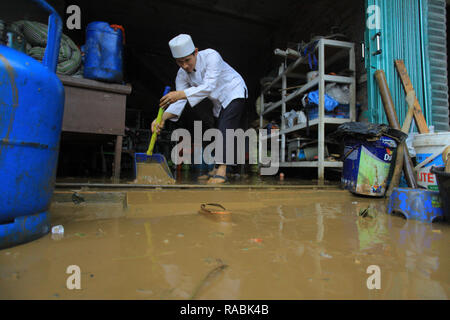 Bogor, West Java, Indonesien. 2 Jan, 2019. Bewohner gesehen sein Haus Reinigung während eines Hochwassers. Dutzende Bewohner waren aufgrund der Flutkatastrophe in hitdorf Rancamaya Cikobak RT 03/04, Rancamaya, Bogor Stadt evakuiert. Diese Flut begannen dutzende Häuser in Kampung Rancamaya Cikobak aufgrund der Strömung der Cisadane Nebenfluss, der Cimakaci Fluss überfließen zu schlagen. Credit: Adriana Adinandra/SOPA Images/ZUMA Draht/Alamy leben Nachrichten Stockfoto