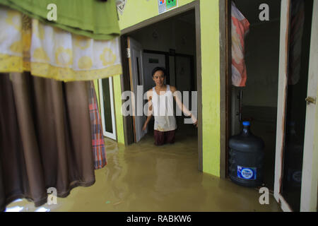 Bogor, West Java, Indonesien. 2 Jan, 2019. Ein Bewohner steht Taille tief im Wasser in seinem Haus während eines Hochwassers. Dutzende Bewohner waren aufgrund der Flutkatastrophe, dass Dutzende von Häusern Hit in Kampung Rancamaya Cikobak aufgrund der Strömung der Cisadane Nebenfluss, der Cimakaci Fluss überfließen evakuiert. Credit: Adriana Adinandra/SOPA Images/ZUMA Draht/Alamy leben Nachrichten Stockfoto