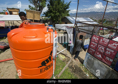 Palu, Sulawesi, Indonesien. 3. Jan 2019. Arbeitnehmer füllen Sie sauberes Wasser für Flüchtlingslager in der Balaroa, Palu, Zentral-sulawesi Dorf integrierte Camp, Indonesien, Donnerstag (1/3/2019). Nach der Eingabe in eine Erweiterung des Notfall- oder drei Monate nach der Katastrophe, Flüchtlinge begann die Schwierigkeit von sauberem Wasser zu fühlen, weil die Versorgung aus der Freiwilligen rückläufig war und in der Zwischenzeit gibt es keine Wasserquellen im Camp. Credit: bmzIMAGES/Alamy leben Nachrichten Stockfoto