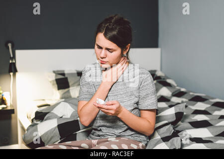 Das Thema saisonale Erkältung, Schnupfen Grippe virus Infektion. Junge kaukasier Frau zu Hause Schlafzimmer Bett verwendet spray Tropfen Medizin an ihre Nase für Sno Stockfoto